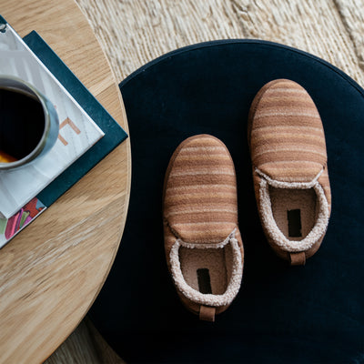 The Cobian Borrego Moccasin next to a coffee table with magazines and coffee #color_tan