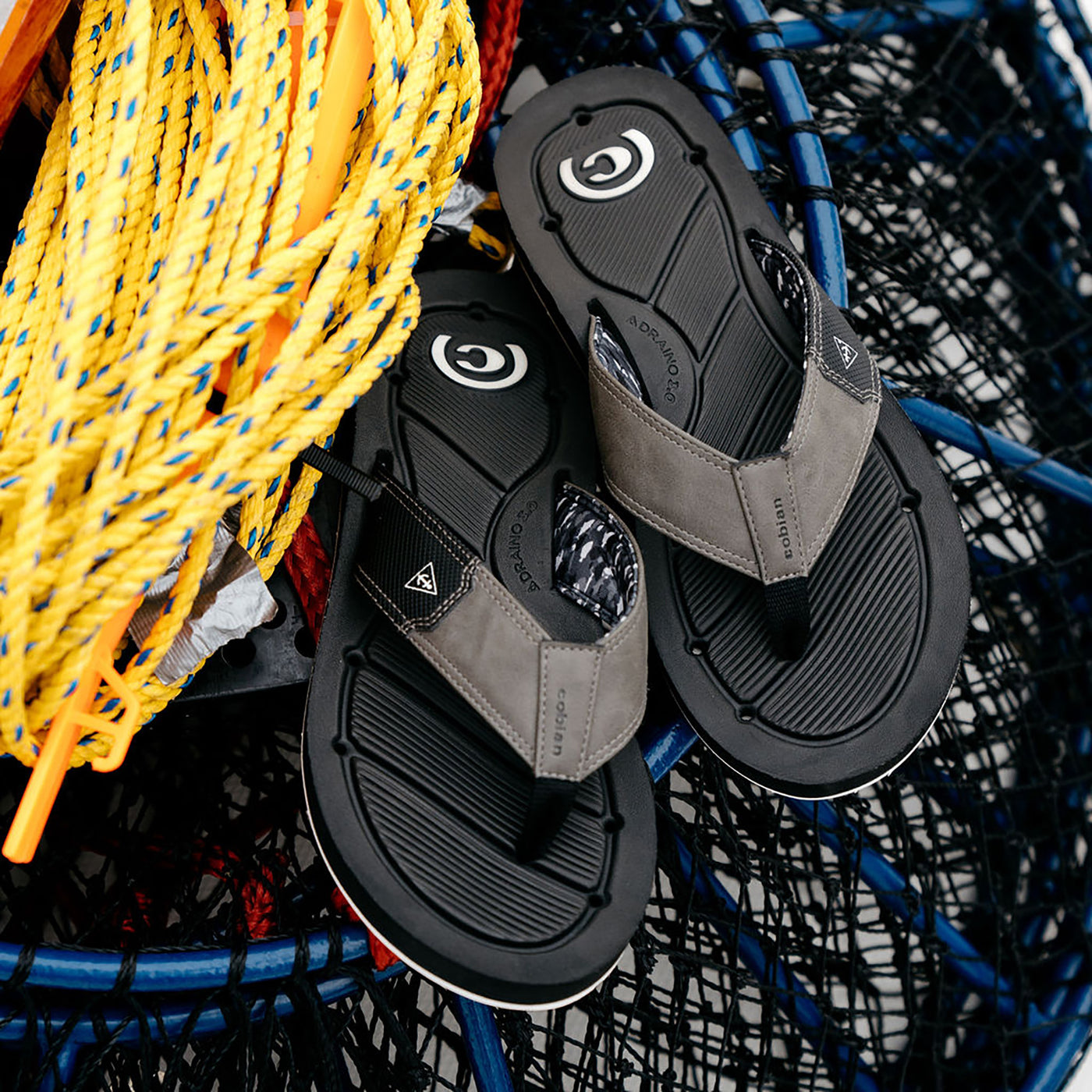 Cobian Draino 3 black sandals sitting on a lobster hoop net #color_black