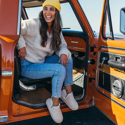 A woman wearing the Cobian Cabrillo Bootie Cream, seated in a classic pickup truck #color_cream