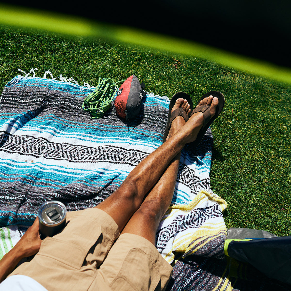 Aerial shot of model lounging in a tent next to some climbing gear wearing the ARV 2 Trek Chocolate #color_chocolate